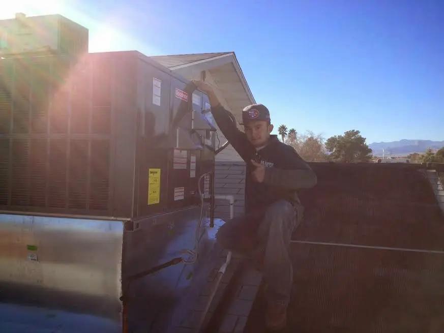 HVAC technician performing Boiler Repair on a rooftop unit in Dalton